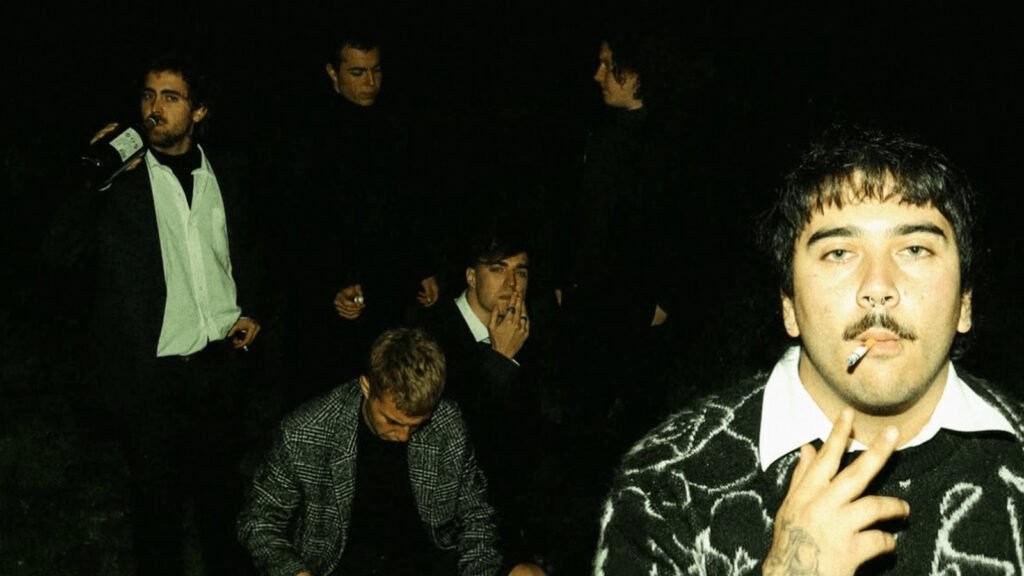 En la imagen se aprecia a la banda él se quemará en un fondo oscuro con alguno de los intengrantes bebiendo alcohol y otros fumando.