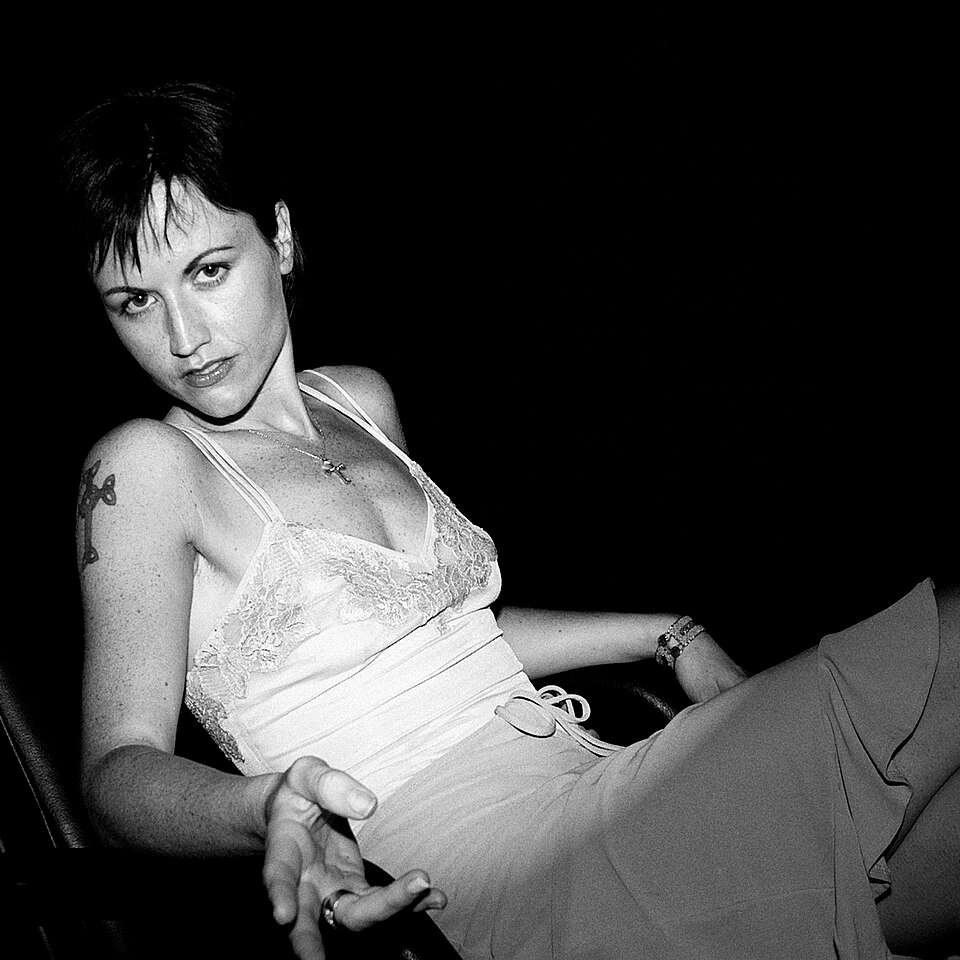 Retrato en blanco y negro de la vocalista Dolores O´Riordan. Fotografía sacada en 2001 por el fotógrafo Roger Woolman en 2001. Extraída de Wikipedia Commons.